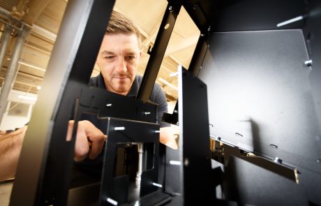 Assembly operator putting together internal fixings for a self service kiosk